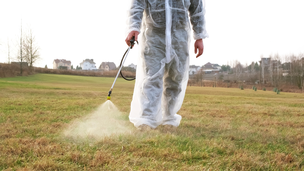Spraying for ticks in a backyard field - professional tick control yard treatment